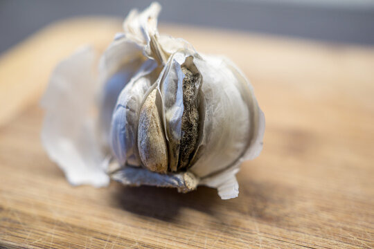 closeup of moldy garlic on a wooden board in the kitchen