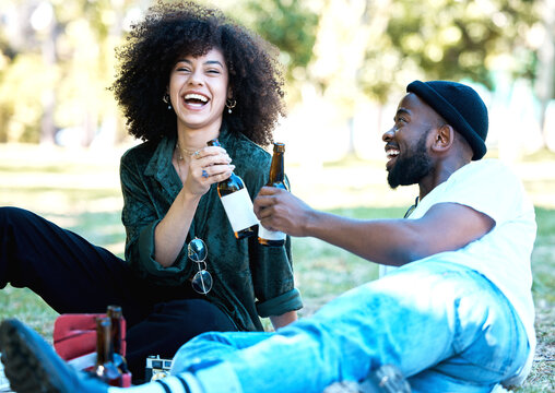 Wine bottle, celebration and couple having a picnic date at the park or on a field with nature bokeh. Young and excited black man and woman or people with alcohol drink and enjoying outdoor together