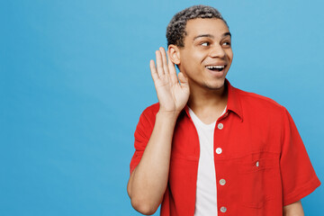 Young curious nosy fun man of African American ethnicity 20s he wear red shirt try to hear you...