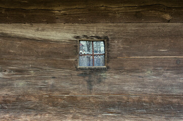 Window in an old wooden house. Texture of ancient architecture