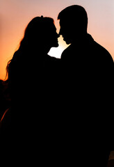 Silhouette of a young bride and groom on the background of the sunset