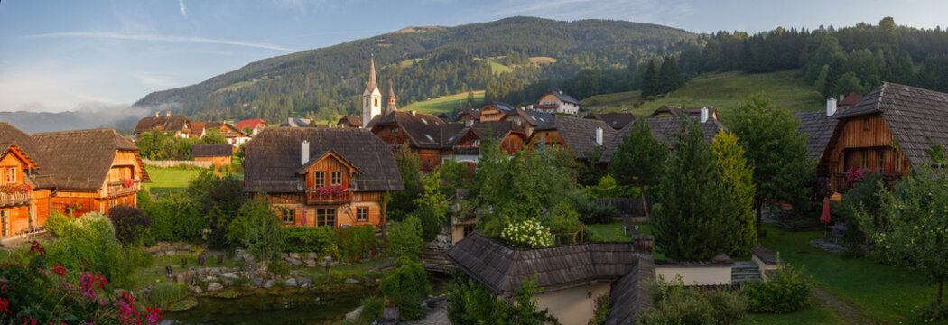 Village of Sankt Michael im Lungau, Salzburger Land, Austria, at sunset, with mountains in the background, summer, with wooden houses and church (Panorama)