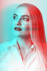 Fashion, style and make-up concept. Close-up studio portrait of beautiful and sexy looking blonde woman in red and blue colors split effect. Model wearing white shirt and looking aside the camera
