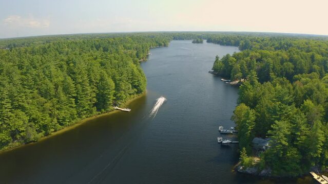 Drone View Of A Jet Ski Driving Away Down A River Away From Camera On A Beautiful Summer Day. Aerial.