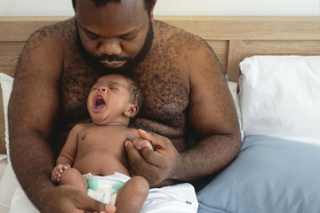 Happy African father hold embrace cute baby son, shirtless African daddy enjoying time together at home, selective focus