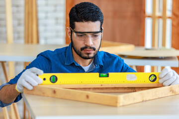 Indian professional bearded male engineer architect foreman labor worker carpenter using water level magnetic ruler tool checking alignment