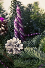 Christmas composition. Candles and a silver cone in pine branches.
