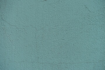 Close shot of old dusty mint colored painted wall with cracks