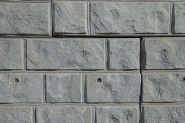 Closeup of light grey unpainted brick veneer wall