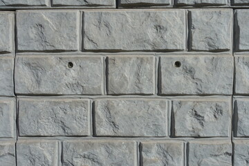 Front view of light grey unpainted brick veneer wall
