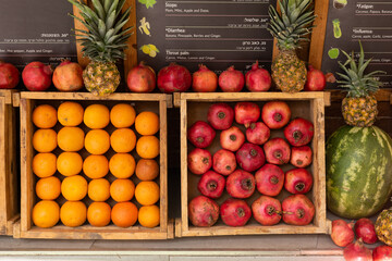 Crates packed with ripe oranges and pomegranate fruits at a juice bar on a street in Jerusalem,...