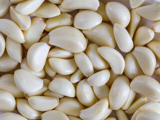 Closeup of peeled cloves of garlic, organic spicy food full frame background