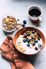 Fototapeta na wymiar Breakfast bowl of yogurt with chocolate granola, blueberries and banana. Healthy eating, dieting concept