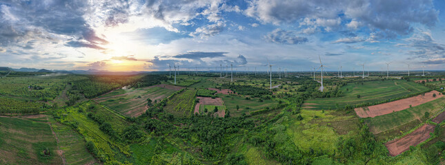 Aerial panorama view of countryside with windmills, Agriculture fields and different variety of harvest, Panaramic view of forest with sunset sky, Twilight sky and cloudscape. clean energy concept