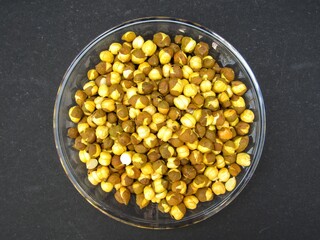 Roasted chickpeas on a plate on black background