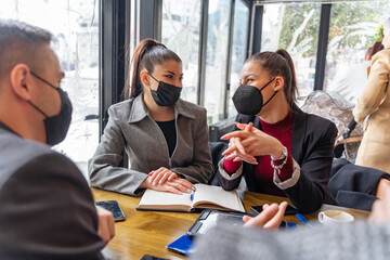 Fototapeta premium Discussing the plans and ideas for the company, covid masks