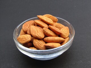 Almonds in a bowl on black background 