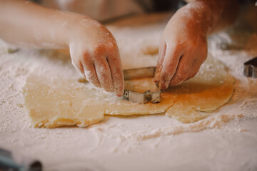 Closeup view on hands how mother with son preparing flour for cookies in the kitchen