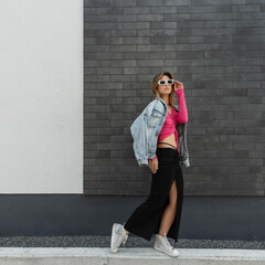 Cool fashion beautiful hipster girl in stylish bright clothes with jeans jacket, pink top, dress...