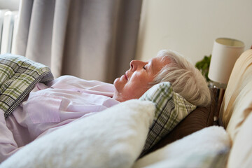 Alte Frau  schläft friedlich im Bett im Altersheim