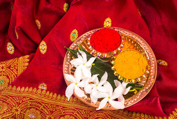 Mangalsutra or Golden Necklace to wear by a married hindu women, arranged with traditional saree with haldi, kumkum and flowers on plate.