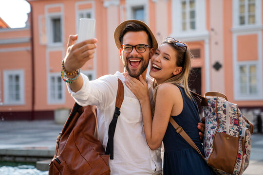 Happy traveling couple taking selfie, having fun on vacation. People technology happiness concept.
