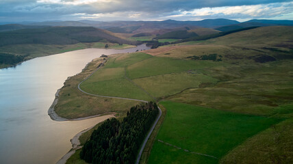 Naklejka premium aerial picture of grassy meadows and a water reservoir at twilight