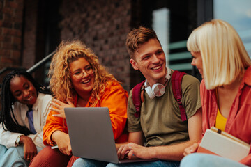 Cheerful college student using laptop outside.