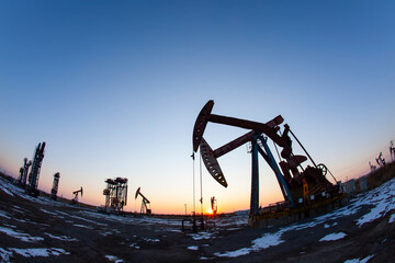 In the evening, oil pumps are running, Silhouette of beam pumping unit