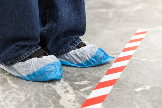 Legs In Polyethylene Shoe Covers In A Medical Center.