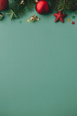Christmas flat lay. Stylish christmas festive decorations, confetti, fir branches on green background. Seasons greetings card template, space for text. Merry Christmas and Happy Holidays! © sonyachny