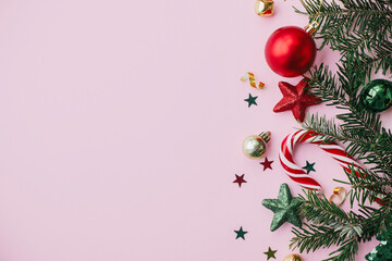 Modern Christmas Flat lay. Stylish christmas festive decorations, confetti, fir branches on pink background. Merry Christmas and Happy Holidays! Creative Seasons greeting card, space for text