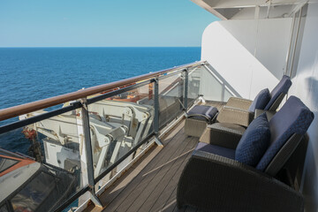 Modern balcony deck chairs sun loungers with table on balcony patio terrace veranda stateroom cabin suite terrace on ocean liner cruiseship cruise ship at sea with beautiful ocean views