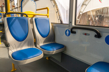 Obraz premium New comfortable seats inside a modern public bus. Seats on the bus for the elderly, people with disabilities and passengers with children. Special seats for certain categories of passengers.