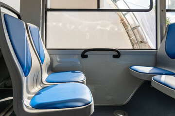 New comfortable seats inside a modern public bus. Seats on the bus for the elderly, people with disabilities and passengers with children. Special seats for certain categories of passengers. © Pokoman