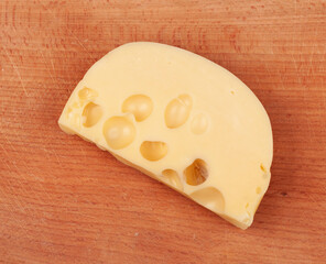 Pieces of cheese on a wooden cutting board