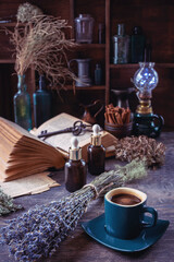 Coffee in a cup. Magical setting. Dry herbs on the table.