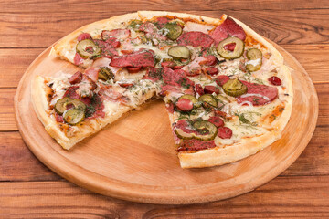 Slices of pizza with different sausages on pizza serving board
