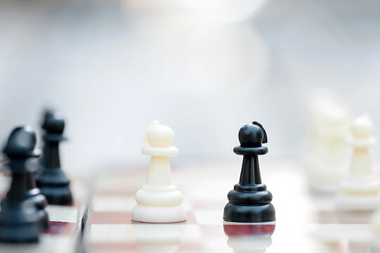 Two chess pawns facing each other on a chessboard. The concept of rivalry, competition