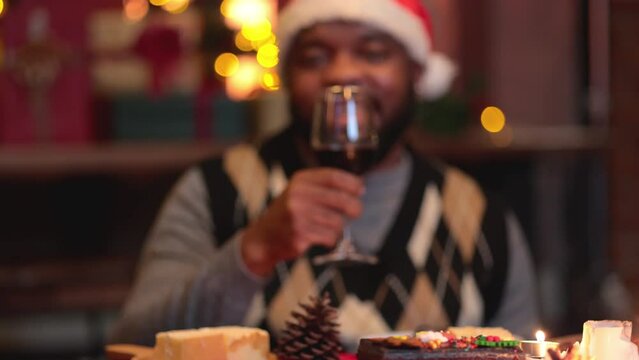 Groups of people celebrate Christmas eve and have dinner at night which have many food and wine on the table.
