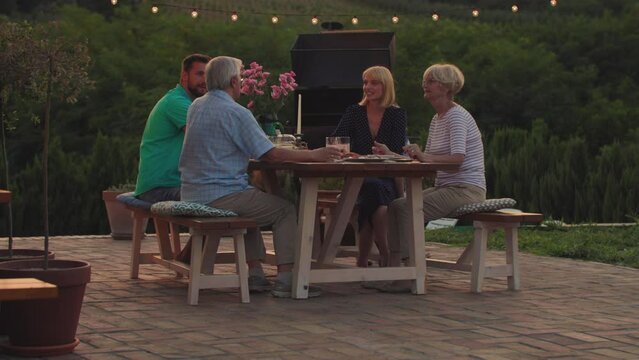 Affectionate family enjoying dinner while their get together in the backyard