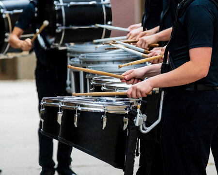 section of a marching band drum line warming up for a parade