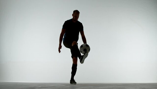 Super slow motion soccer player dribbling a ball on white background. Filmed on high speed cinema camera, 1000fps.
