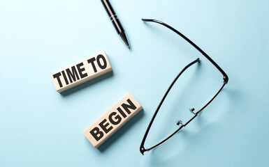 TIME TO BEGIN text on the wooden block ,blue background