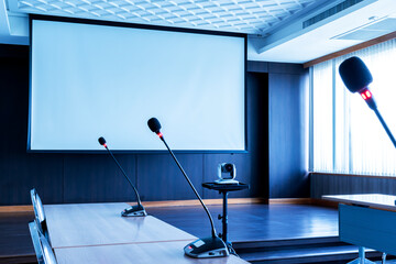Microphone on table with projector screen background in meeting room