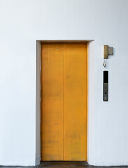 Yellow lift closed door with white wall background