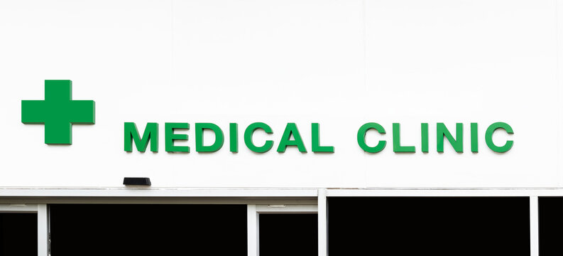 Icon green cross with message MEDICAL CLINIC on white wall building