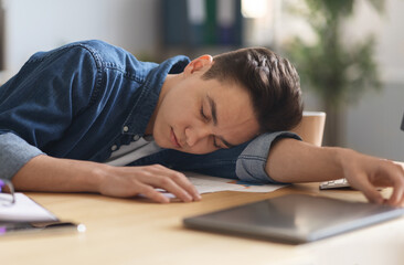 Overworking Concept. Young Male Employee Sleeping At Desk In Office
