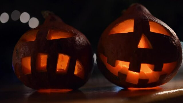 two carved pumpkins during the halloween celebration at night in the city.