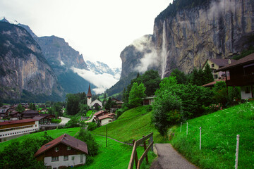 Amazing touristic alpine village with famous church and Staubbach waterfall, Lauterbrunnen, Switzerland, Europe.